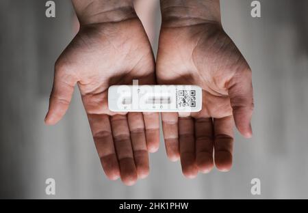 child's hands holding a positive COVID Lateral flow test Stock Photo