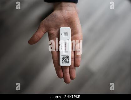 child's hand holding positive lateral flow COVID test Stock Photo