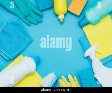 Cleaning kit detergents napkins sponges gloves, blue background. The concept of home cleaning or cleaning company services Stock Photo