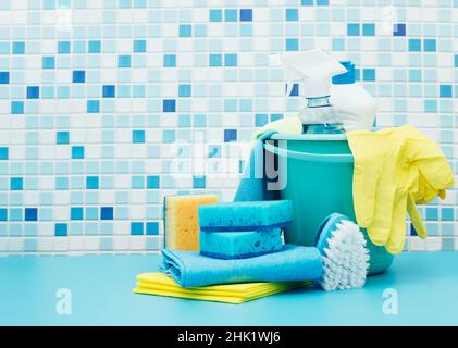 Cleaners and detergents in bucket, accessories for cleaning various surfaces and rooms blue background Stock Photo