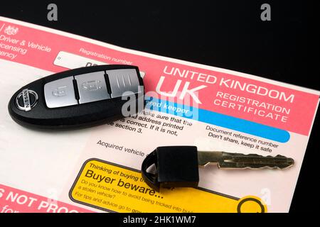 Genuine UK registration certificate for a purchased car and car key on top of it. Registration document also known as a vehicle log book V5C. Stafford Stock Photo