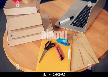 Set of packaging materials and a portable computer on the table Stock Photo