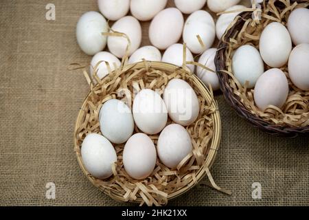 Raw organic whhite eggs in wicker basket Stock Photo