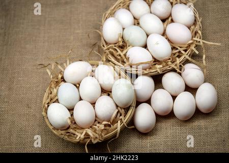 Raw organic whhite eggs in wicker basket Stock Photo