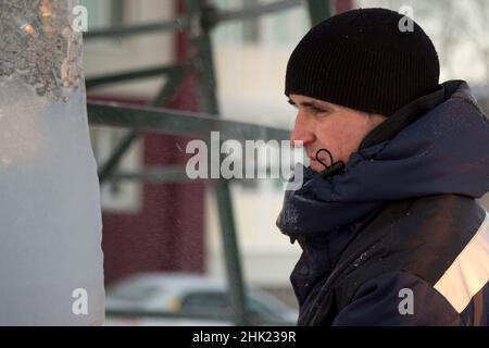 Portrait of a male assembler at the workplace in winter overalls Stock Photo