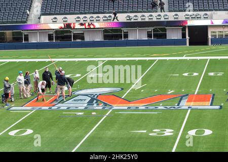 01 February 2022, US, Inglewood: Workers paint the Super Bowl LVI logo on  the field at SoFi Stadium. The Los Angeles Rams and Cincinnati Bengals will  meet here on Feb. 13, 2022 (