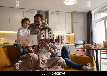 Sick female showing picture to girl and her father Stock Photo