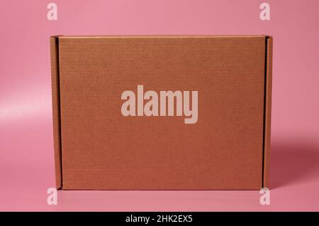 Closed cardboard box on a solid pink background Stock Photo