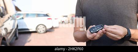 Man holds in hands push-button remote control from car closeup Stock Photo