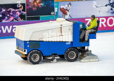 Worker using old rusty ice resurfacer Zamboni resurfacing machine for preparing outdoor ice skating rink in Sofia, Bulgaria Stock Photo