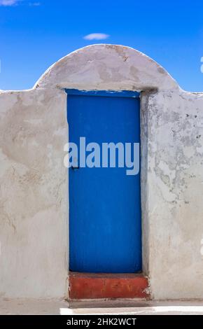 Europe, Greece, Thirasia. White wall and blue door against blue sky. Stock Photo