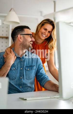 Happy couple doing business together working at small office Stock Photo