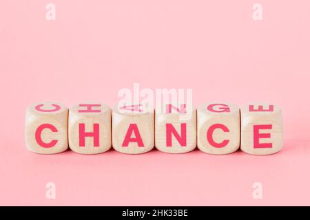 Words chance and change written with wood cubes on pink background - Concept of woman, chance and empowerment Stock Photo