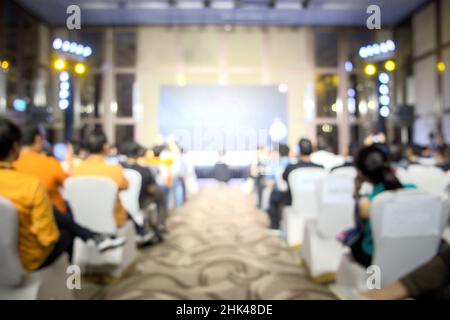 Blurred view from behind the audience waiting to hear from the speaker in the seminar in the building on blurred background Stock Photo