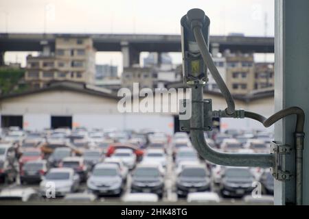 Rear view of CCTV cameras to monitor group of vehicles on park in the parking lot outside of the building Stock Photo