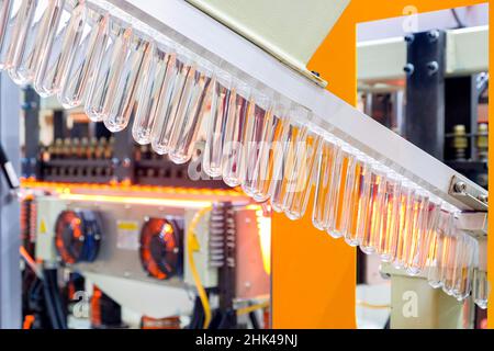Close-up rows of clear plastic material on machinery to make a clear plastic bottle, industrial 4.0 Stock Photo