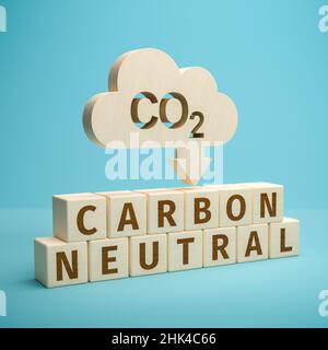 CO2 reduction concept. Cloud shaped object with the word CO2 punched out and an arrow pointing down above wooden toy cubes forming the words Carbon Ne Stock Photo