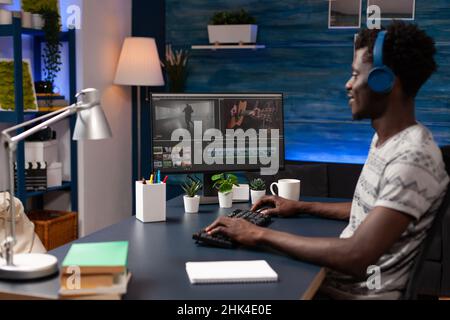 Video maker editor man man working remote from home at montage film editing visual effects using post production software. Filmmaker artist designing creative content in creativity studio Stock Photo