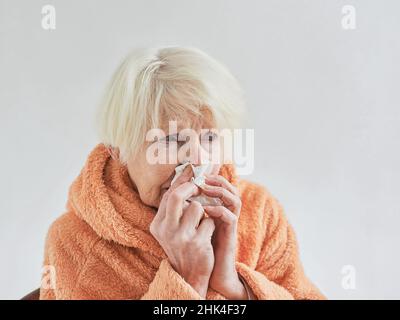 senior ill woman freezing cold at home. Health care, crisis, oldness concept Stock Photo