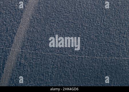 Car's windscreen wiper covered in snow. Frozen window. Stock Photo