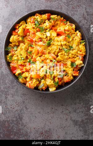 Anda Bhurji is an Indian Style Spicy Scrambled Eggs closeup in the plate on the table. Vertical top view from above Stock Photo