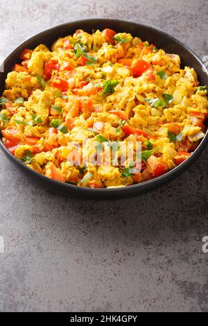 Anda Bhurji is an Indian Style Spicy Scrambled Eggs closeup in the plate on the table. Vertical Stock Photo