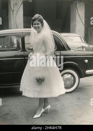 Wedding in Italy during the 1950s: The bride arrives to the church with the car Stock Photo