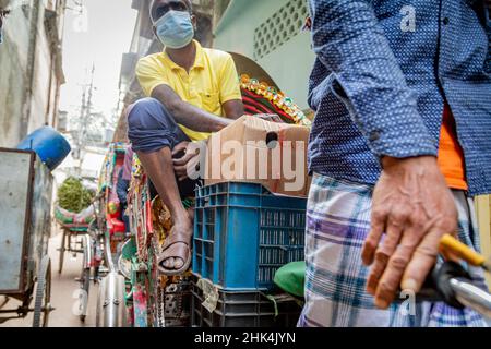 Rickshaw pullers on the streets of Puran Dhaka - Old Dhaka in Bangladesh. The rickshaws are pedal powered tricycles, but used to be pulled by hand, hence 'rickshaw puller'. Nowadays many of the rickshaws are even converted to be powered by electric motor. Stock Photo