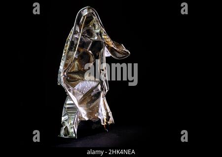 Aluminum foil tray of convenience food shown like a human art sculpture against a black background, avoidable waste from disposable packaging use reso Stock Photo