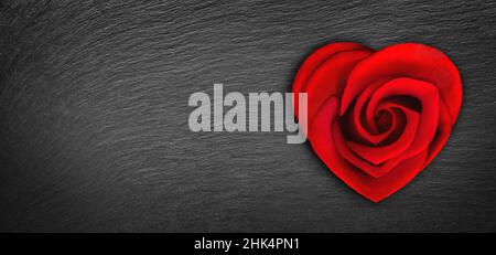 Rose flower in heart shape on dark background with heart shaped bokeh light. Valentine's day celebration. Heart shaped red rose, concept of Valentine' Stock Photo