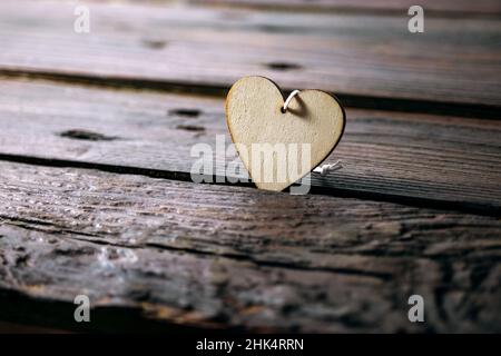 Light wooden heart shape on dark rustic planks, love concept for holidays like valentines, mother's day, father's day and birthday or for everyday lif Stock Photo
