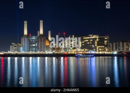 The newly renovated Battersea Power Station and apartments, night shot, reflected in River Thames, Nine Elms, Wandsworth, London, England Stock Photo