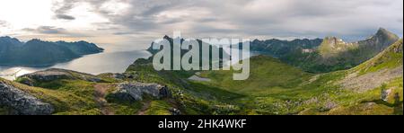 Hikers walking on footpath on Barden mountain above Fjordgard towards Segla peak, Senja island, Troms county, Norway, Scandinavia, Europe Stock Photo