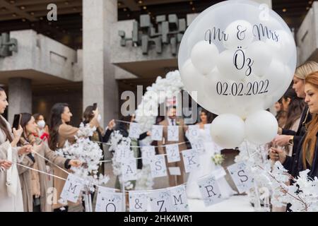 02 February 2022, North Rhine-Westphalia, Cologne: 'Mr & MRS Öz and 02.02.2022' is written on a balloon of a wedding party in front of the registry office. Photo: Rolf Vennenbernd/dpa Stock Photo