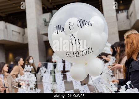 02 February 2022, North Rhine-Westphalia, Cologne: 'Mr & MRS Öz and 02.02.2022' is written on a balloon of a wedding party in front of the registry office. Photo: Rolf Vennenbernd/dpa Stock Photo