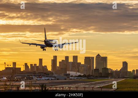 Aircraft landing at London City Airport at sunset, with Canary Wharf and O2 Arena in background, London, England, United Kingdom, Europe Stock Photo