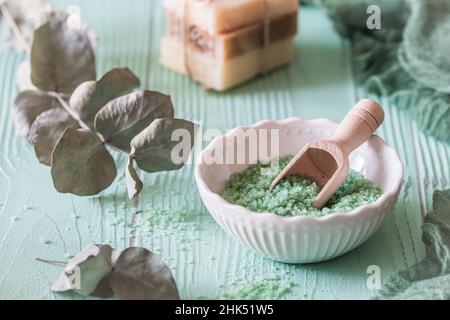 Eucalyptus bath salt in a white bowl on light green background, wellness concept Stock Photo