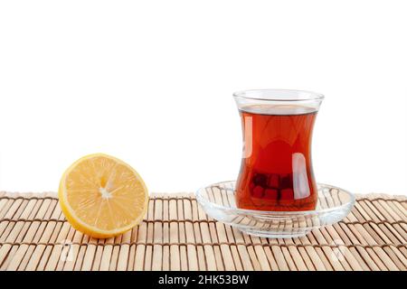 Glass of turkish tea and lemon on white background Stock Photo