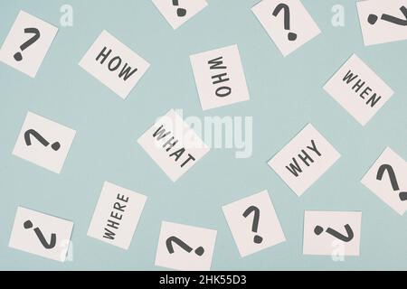The words who what where how why and when are standing on small pieces of paper, question marks, asking for solution, problem solving Stock Photo