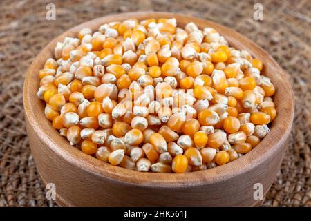 Dry corn seeds in wooden bowl Stock Photo