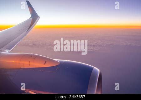 View of airplane engine and clouds over the sea at sunset, Atlantic Ocean, Europe Stock Photo