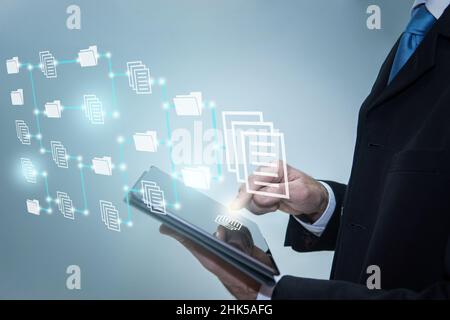 Businessman touching icons on digital tablet. Document Management System, online documentation datab Stock Photo