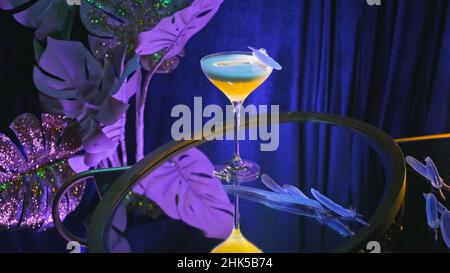 Performance with alcoholic drink on purple background. Stock footage. Alcoholic cocktail on elegant background. Beautiful decoration of alcoholic drin Stock Photo