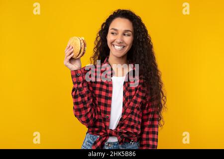 Funny Young Lady Holding Burger At Studio Stock Photo