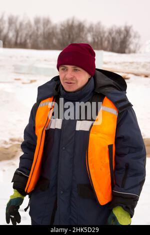 Worker assembler in a reflective vest at the workplace Stock Photo