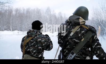Group of special forces weapons in cold forest. Clip. Soldiers on exercises in the forest in the winter. Winter warfare and military concept. Stock Photo