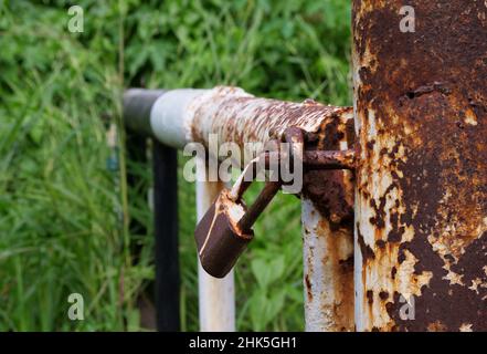 Rusty padlock hanging in the street alley Stock Photo