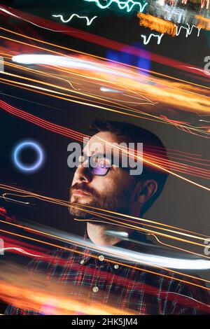 A man observes infinity in the metaverse, surrounded by lights and futuristic effects that transport him to another reality Stock Photo