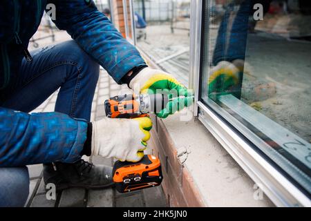 The wizard is engaged in installing windows. Repair work. Stock Photo