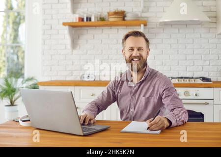 Portrait of smiling businessman work on computer at home Stock Photo